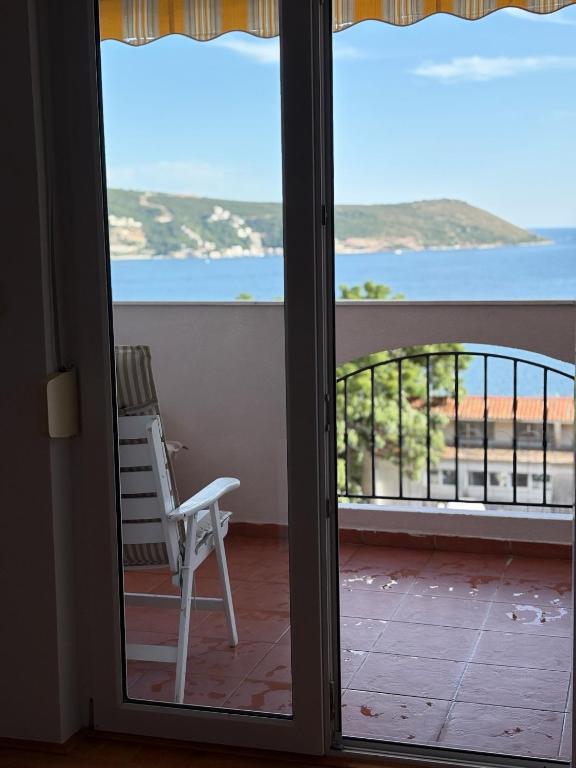 a chair on a balcony with a view of the ocean at Boke vidik in Savina