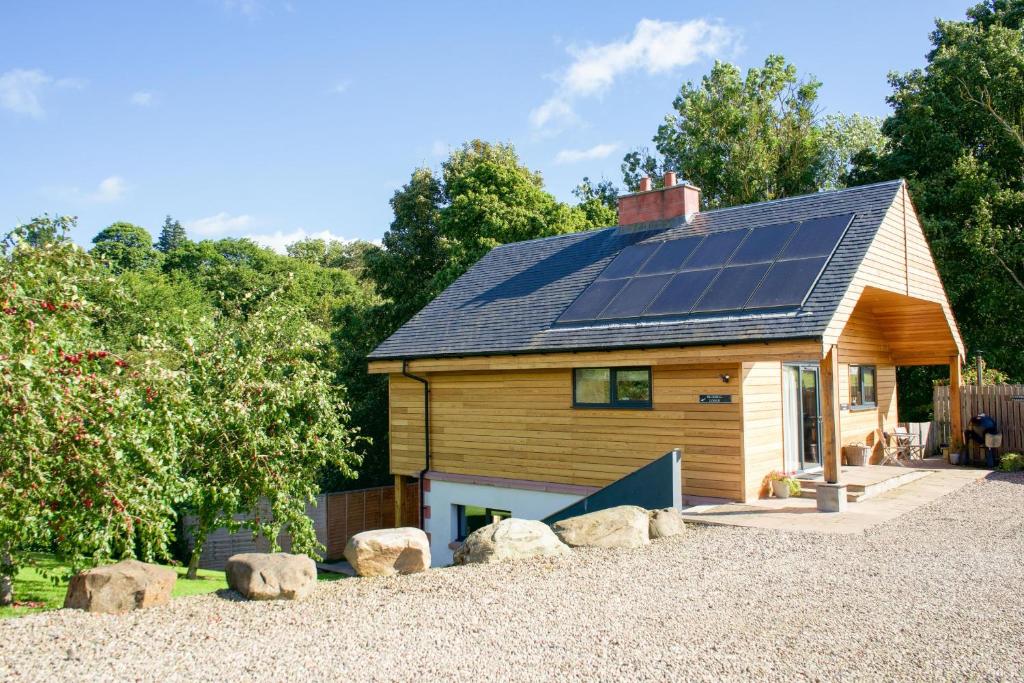 a house with solar panels on the roof at Snowdrop Lodge in Errol