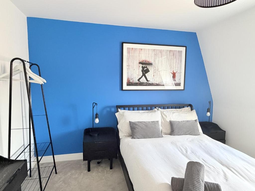 a blue bedroom with a bed with a blue wall at Dawson House in Southampton