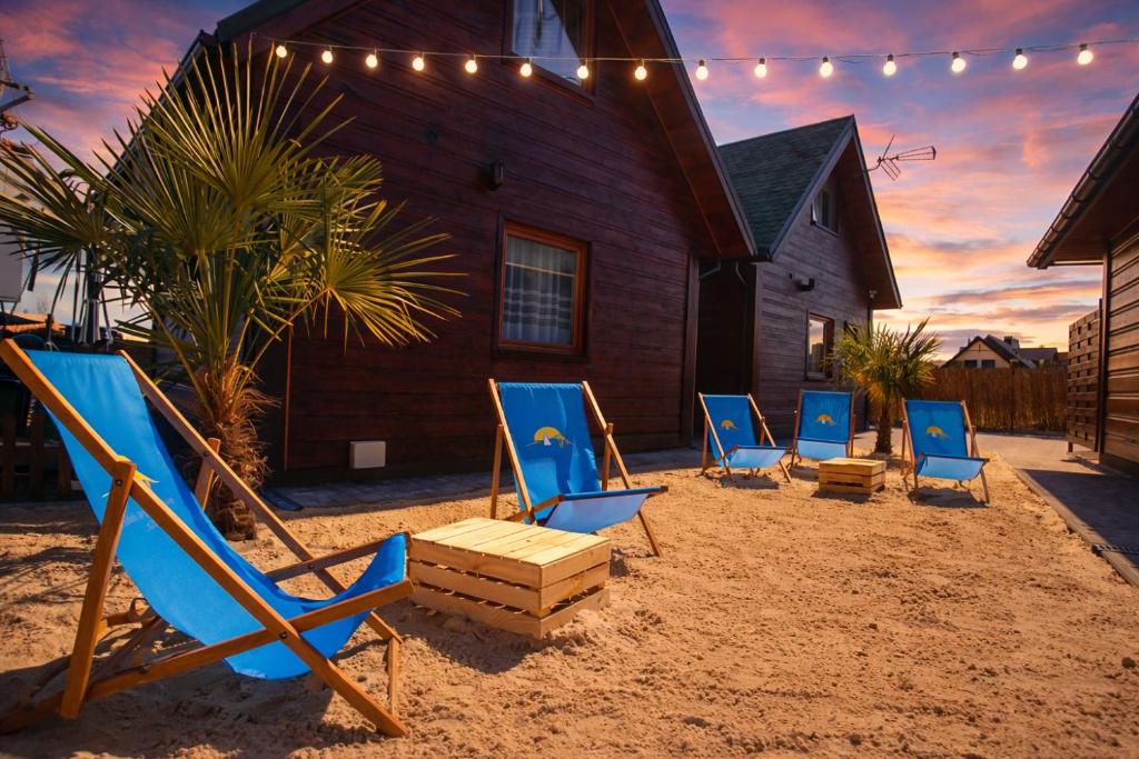 a group of chairs sitting in the sand in front of a house at Ośrodek Wypoczynkowy IGOR nad Jeziorem Żywieckim in Żywiec
