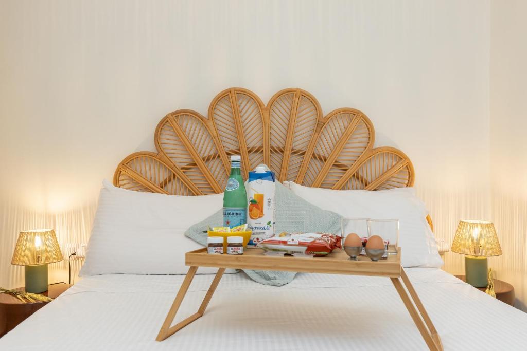 a bed with a table with food and drinks on it at Aila Stay in Corfu