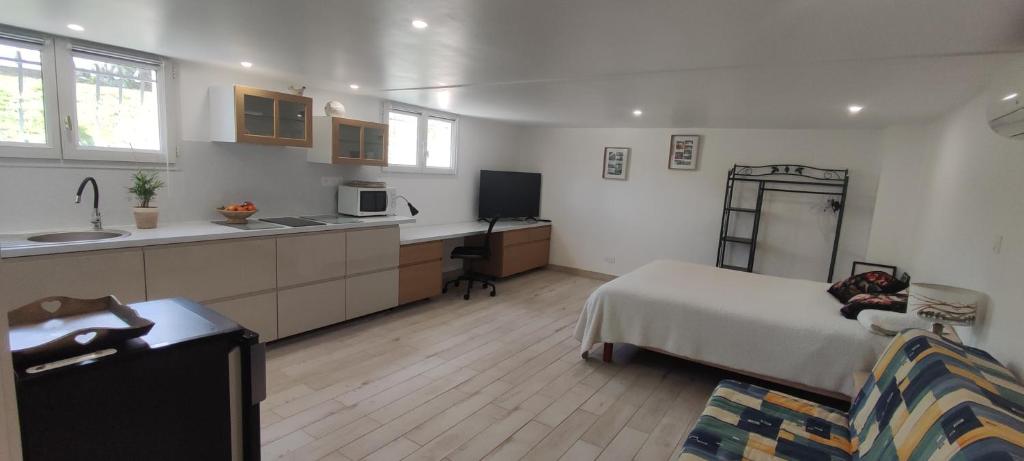 a kitchen and a bedroom with a bed and a couch at La belle étape in Montbrison