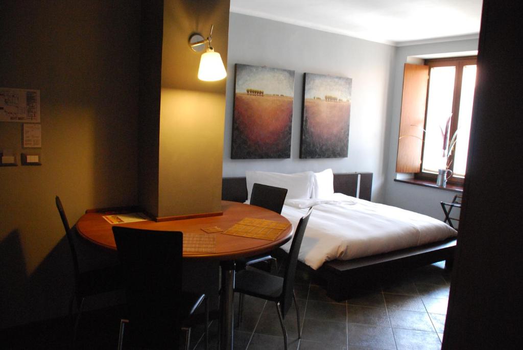 - une chambre avec un lit, une table, un lit, une table et des chaises dans l'établissement Residence Corona Grossa, à Cirié