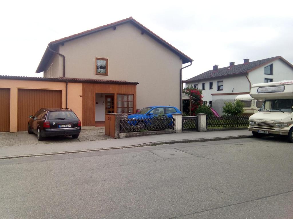 ein Haus, vor dem zwei Autos parken in der Unterkunft Feriennest Faust in Altenmarkt an der Alz