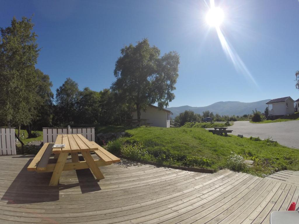 una mesa de picnic de madera en una terraza de madera en Volsdalen Camping en Ålesund