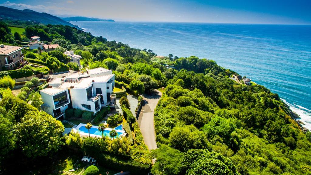 uma vista aérea de uma casa numa colina junto ao oceano em Villa Lanperna em San Sebastián