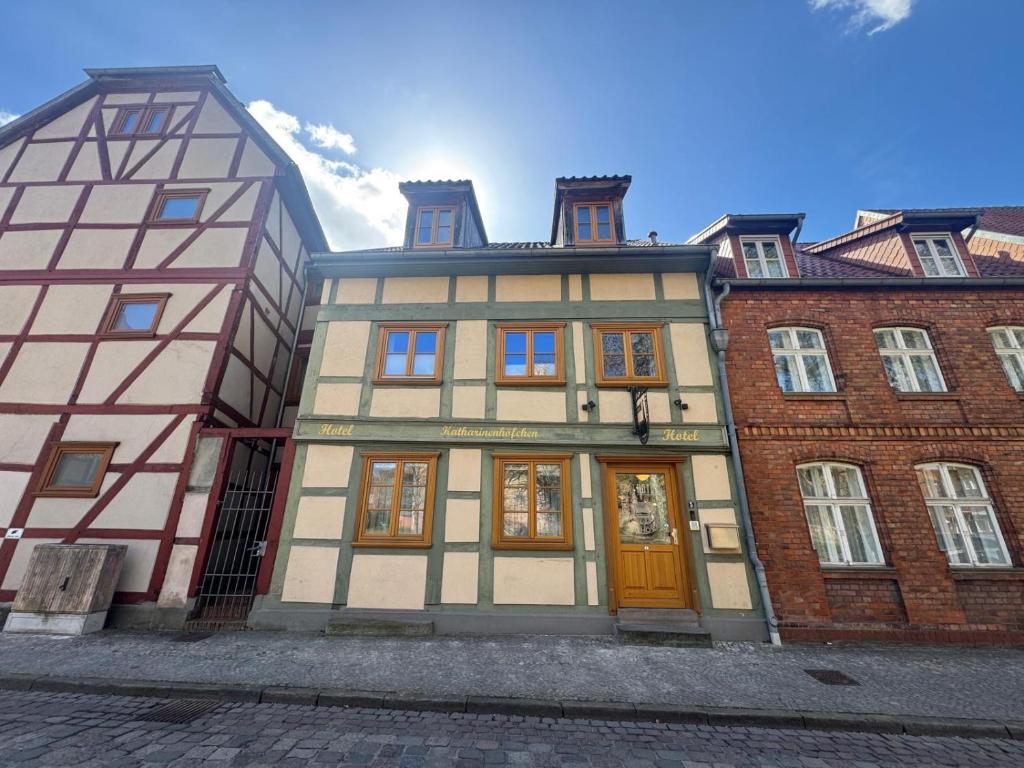ein Gebäude mit einer gelben Tür und ein Backsteingebäude in der Unterkunft Hotel Katharinenhöfchen in Salzwedel