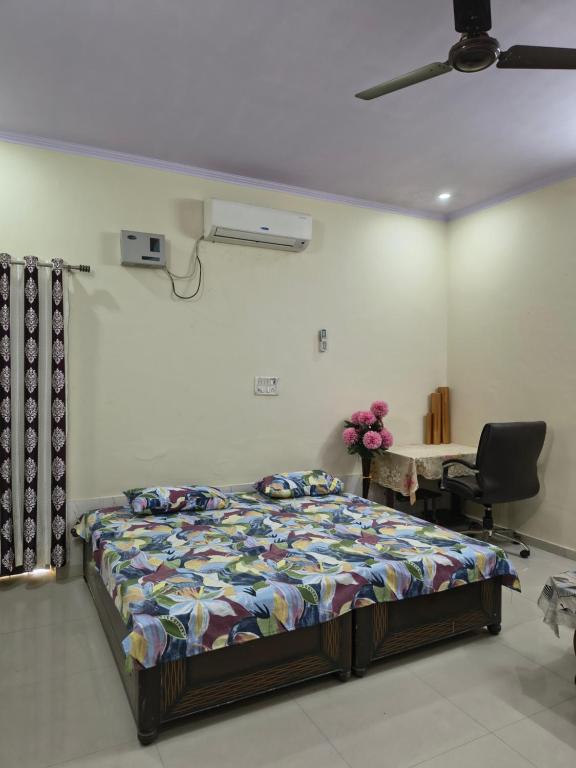 a bedroom with a bed and a desk and a chair at RS Homestay in Bareilly