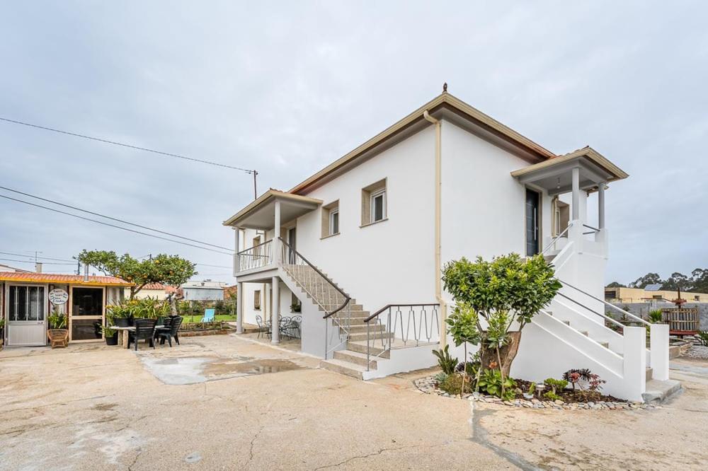 a white house with a staircase in a yard at Moradia Aura Santi in Esposende
