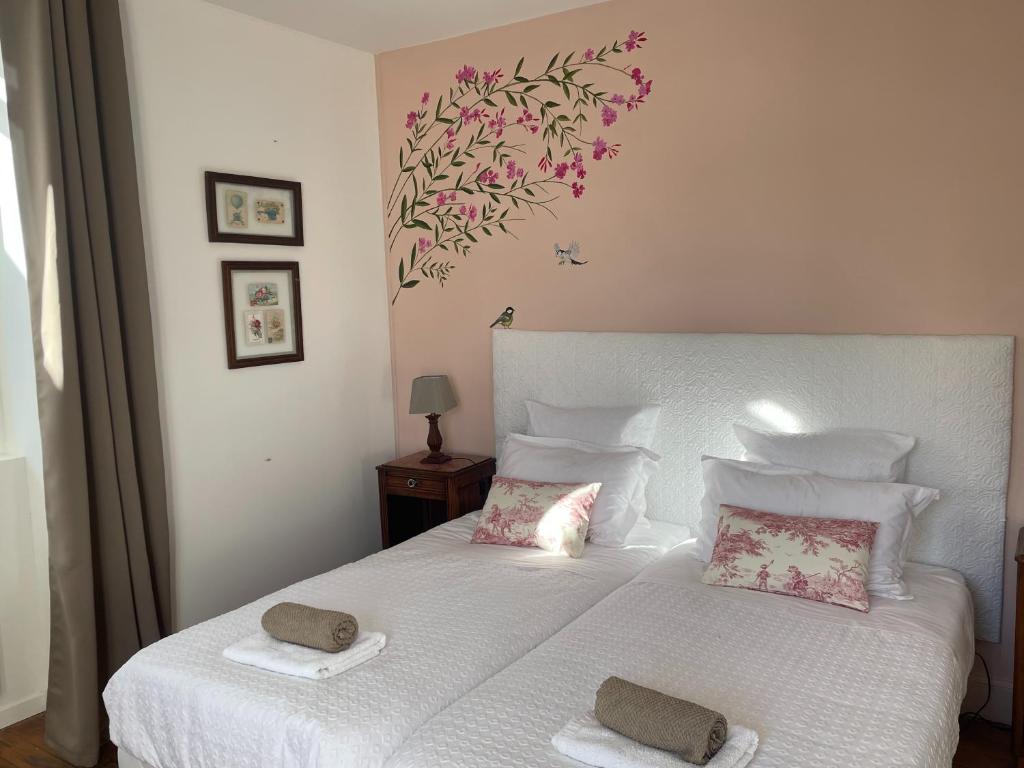 a bedroom with a white bed with two towels on it at couleurs d'ici in Fleurance