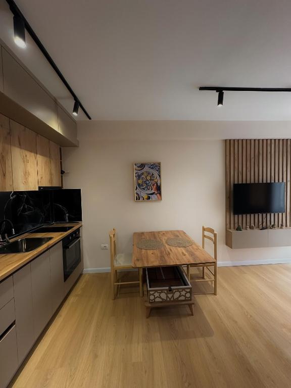 a kitchen with a wooden table and a dining room at Coral Studio Apartment in Shëngjin
