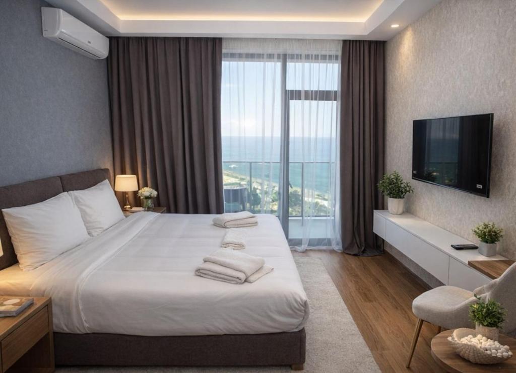a hotel room with a bed and a large window at DreamSide Aparthotel in Batumi