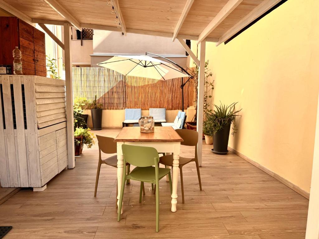 a patio with a table and chairs and an umbrella at Casa Vacanze Roberta in Follonica