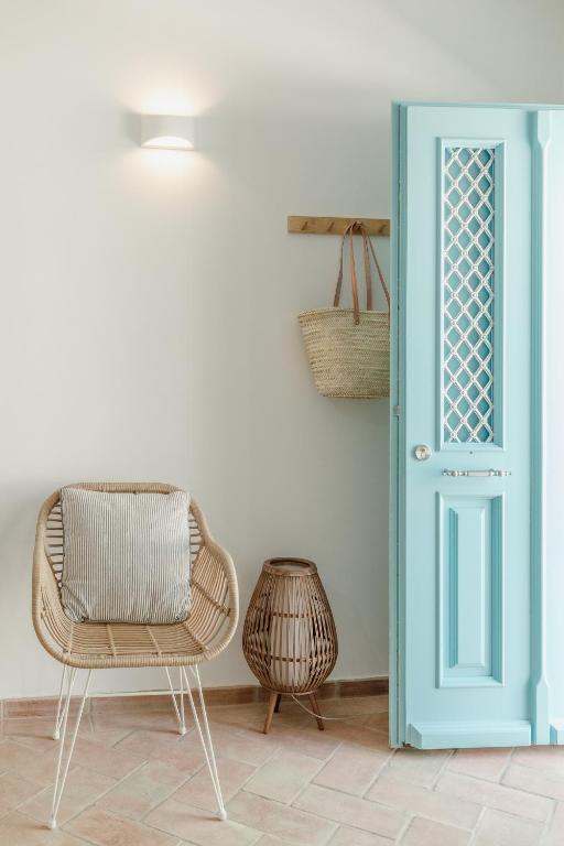a room with two chairs and a blue door at Casa do Céu - Casas do Levante in Olhão