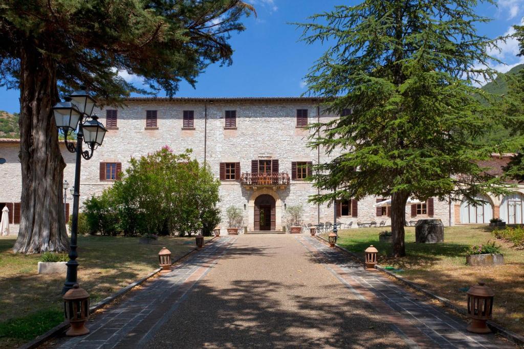 a large stone building with a pathway in front of it at Villa Benveduti in Gubbio