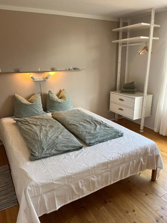a bedroom with a white bed with pillows at Rinkenæshus Das Grosses Zimmer in Gråsten