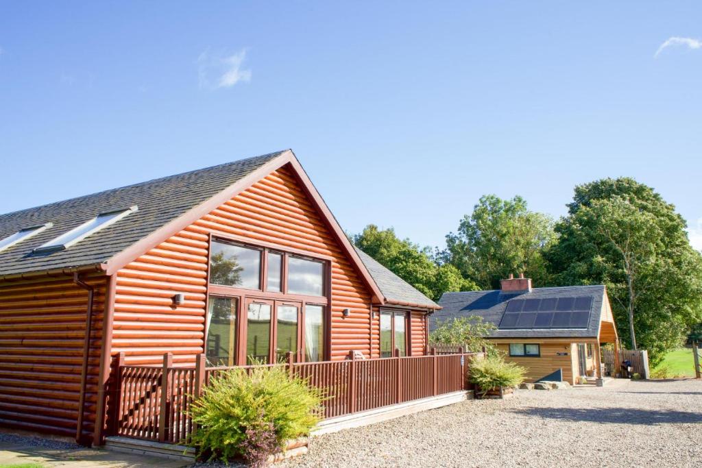 a log cabin with solar panels on the roof at Plum Tree Lodge in Errol