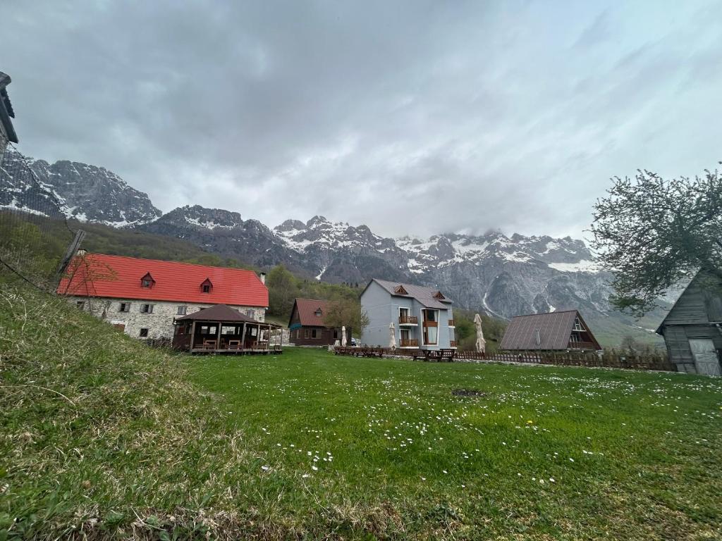 a group of houses with mountains in the background at Bujtina Terthorja in Theth
