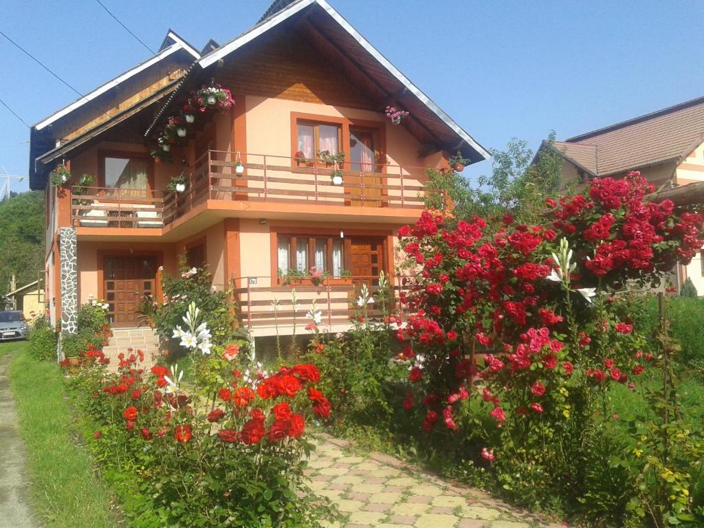 une maison avec des fleurs devant elle dans l'établissement Nopti de Vara Transfăgărășan, à Căpăţîneni-Pămînteni