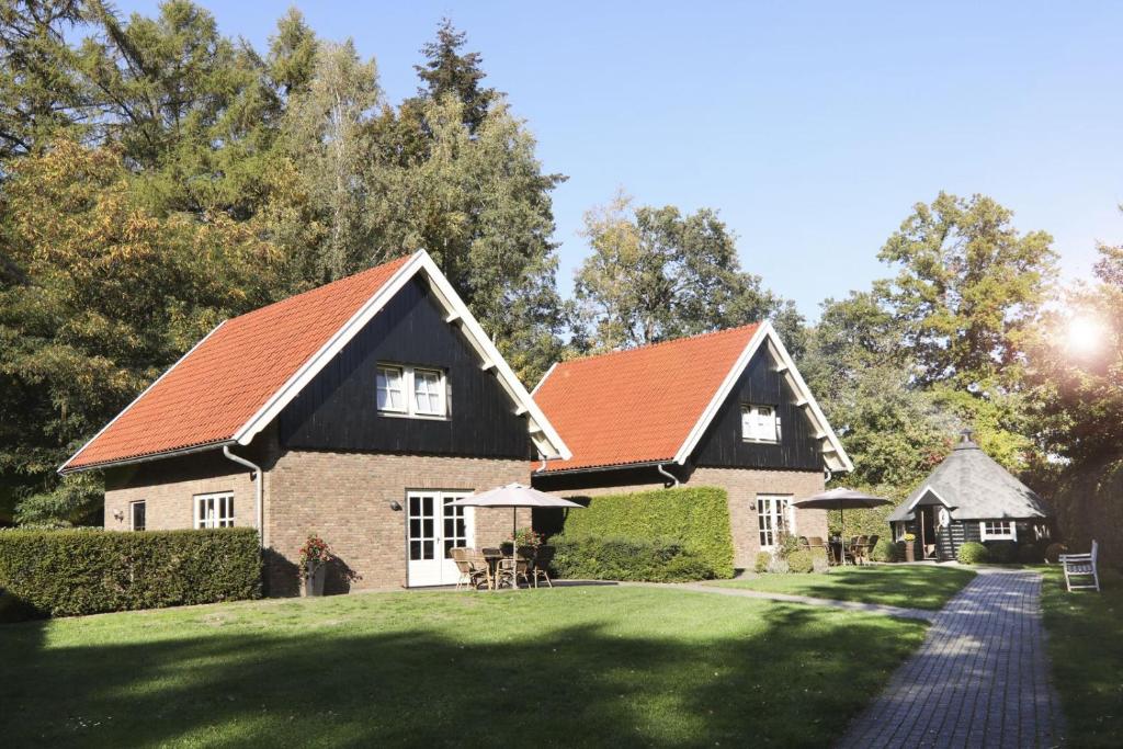a house with an orange roof on a green yard at De Regenboog in Losser