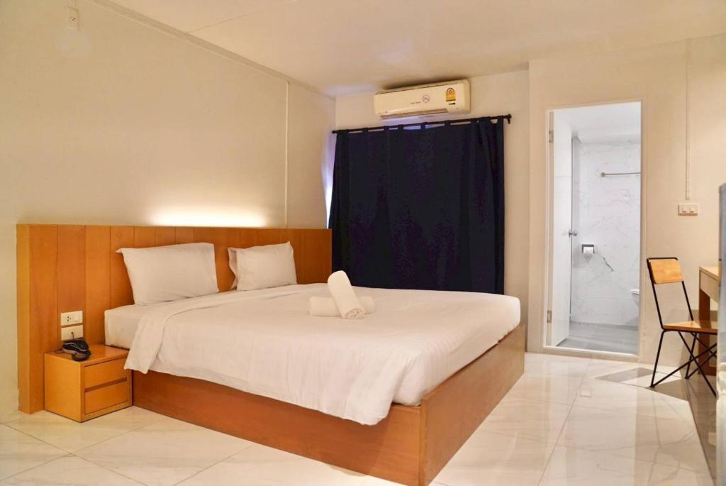 a bedroom with a large bed with a blue curtain at Viewplace Hotel & Residence Lat Phrao 130 in Bangkok