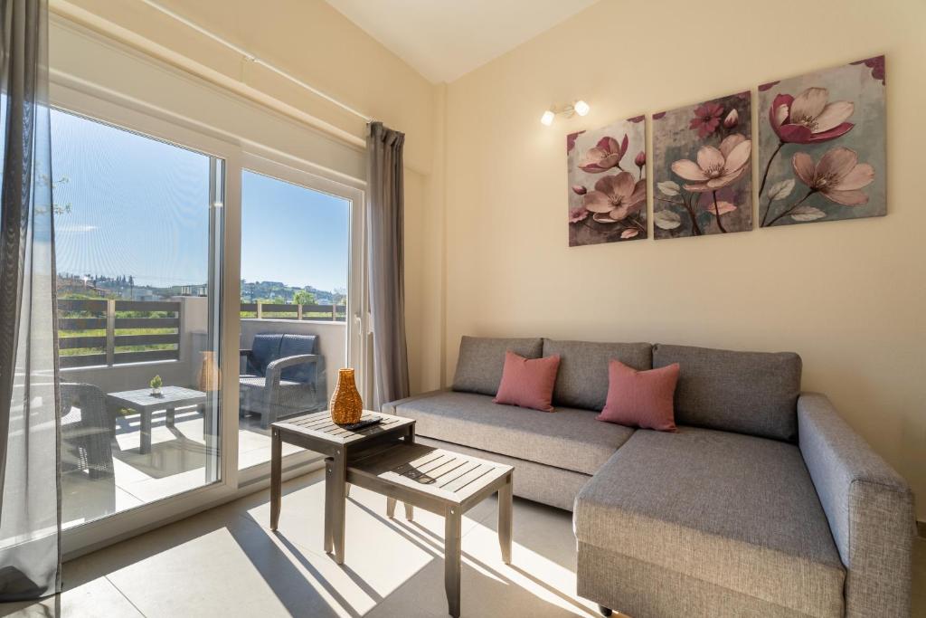 a living room with a couch and a large window at ElGio Maisonette Nikiti in Nikiti