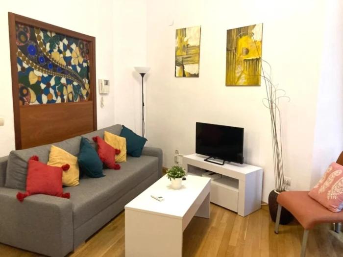 a living room with a couch and a tv at Edificio Histórico en el Centro de Granada cerca de la Catedral y principales puntos de interés in Granada