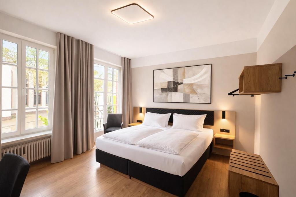 a hotel room with a bed and a desk at Stadthotel Jülich in Jülich