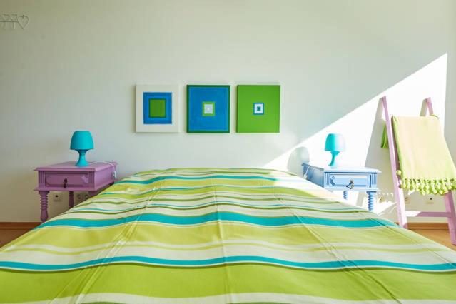 Dormitorio con cama de rayas amarilla y azul en Colors Loft, en Sintra