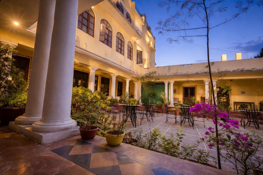 a courtyard of a building with tables and chairs at Kalyan Villa Heritage Stay in Udaipur