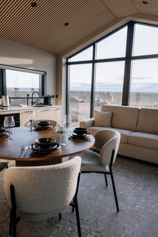 a living room with a table and chairs and a couch at Green Geysir Cottage in Torfastaðir