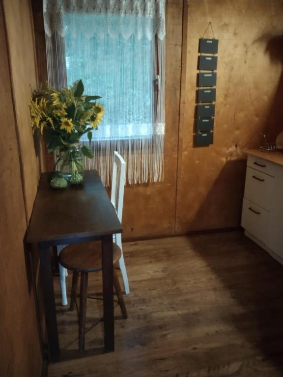 a dining room table with a vase of flowers on it at Domek nad jeziorem in Górzno