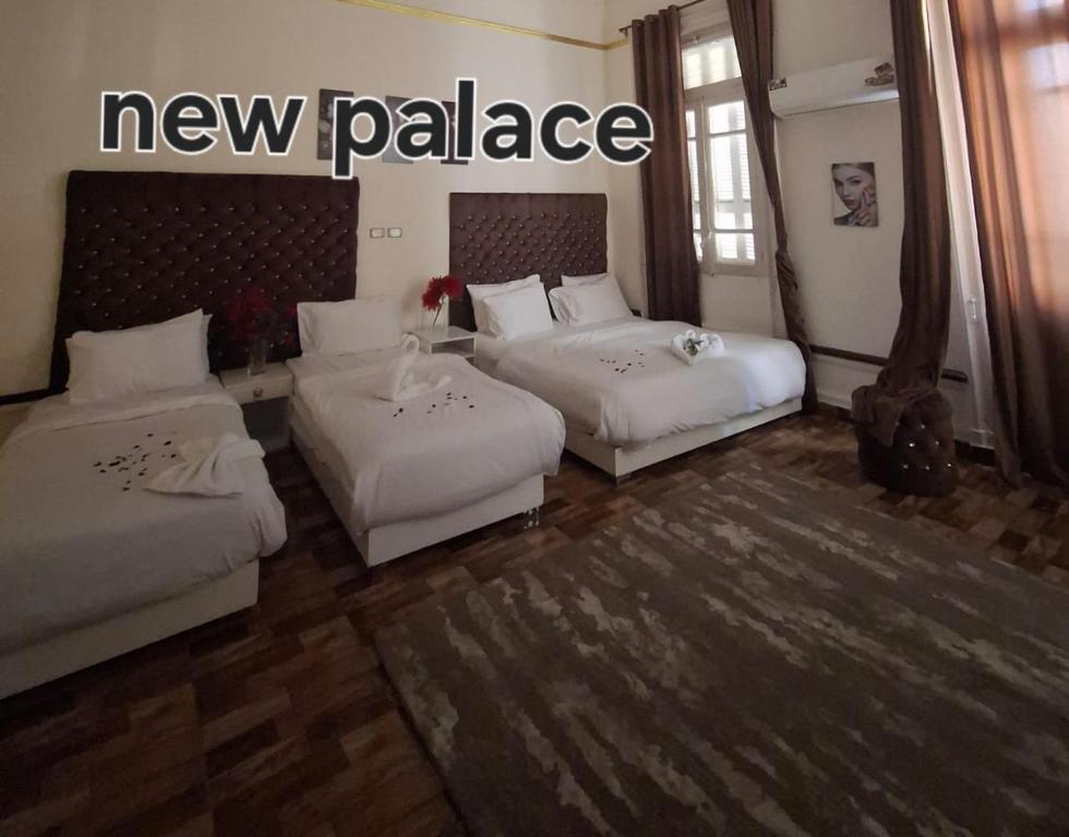 a hotel room with two beds and a new palace sign at New Palace in Cairo