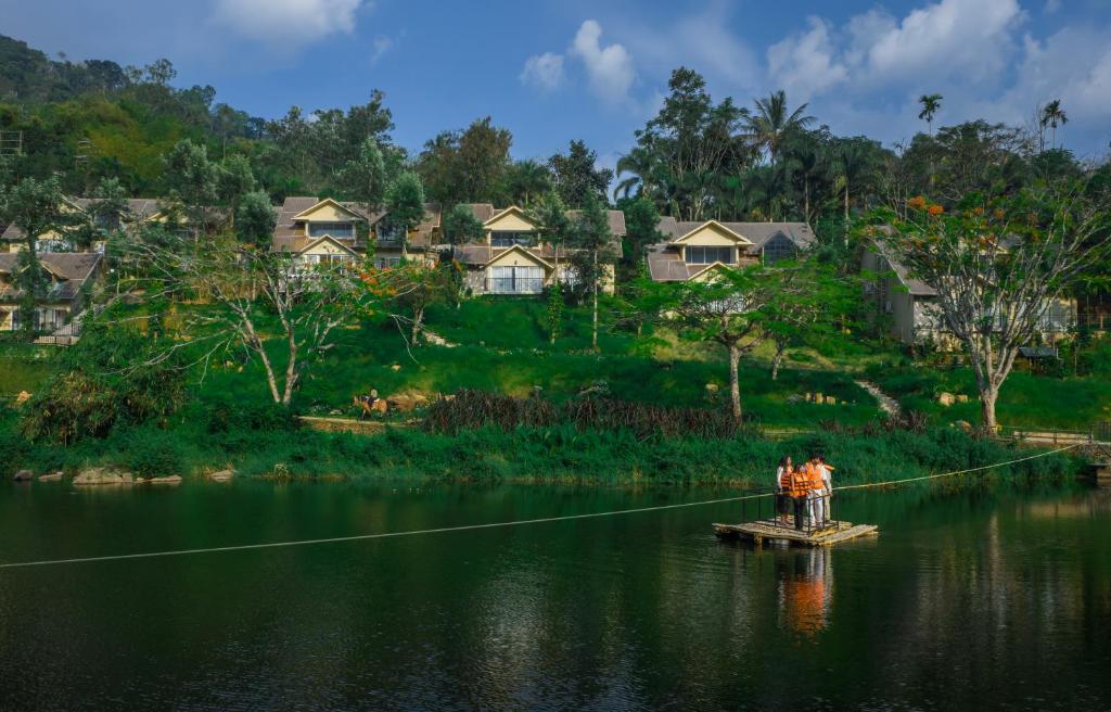 two people on a boat in a river with a rope at Blanket Riverside Resort and Spa in Munnar