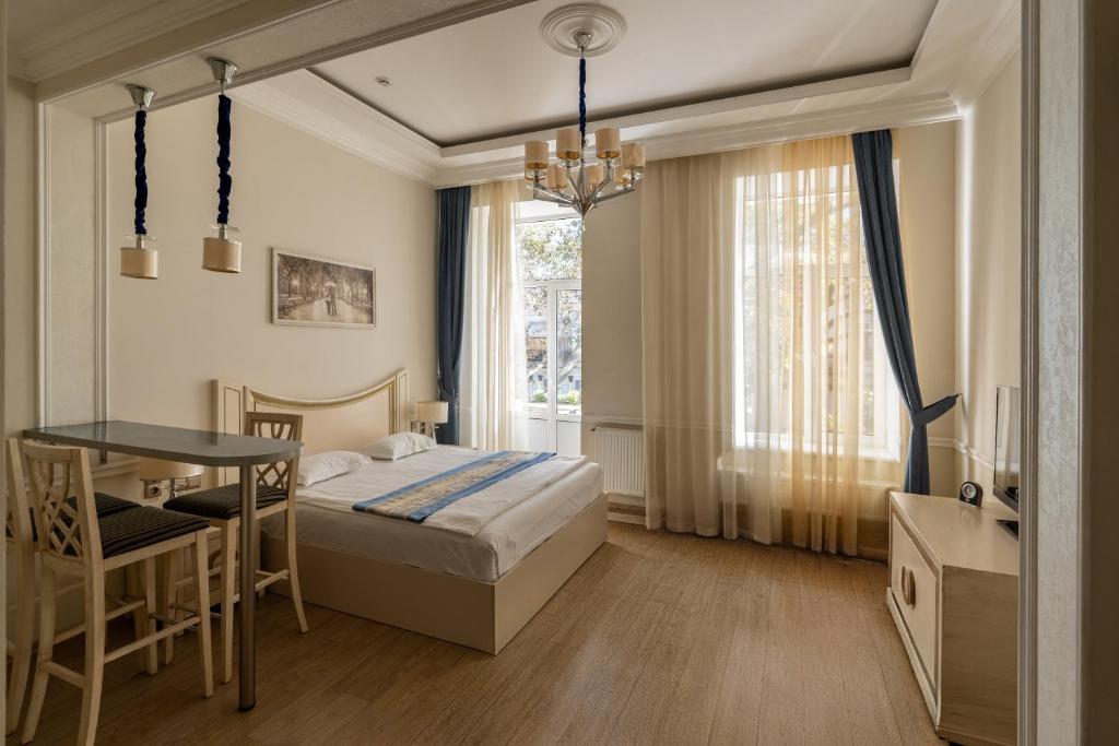 a bedroom with a bed and a table and a window at Metro Hotel Apartments in Odesa