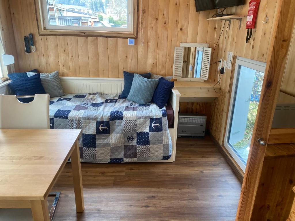 a small bedroom with a bed and a table at Zillerstadl - 5 Sterne Erlebnisresort Aufenfeld, Aschau in Aschau