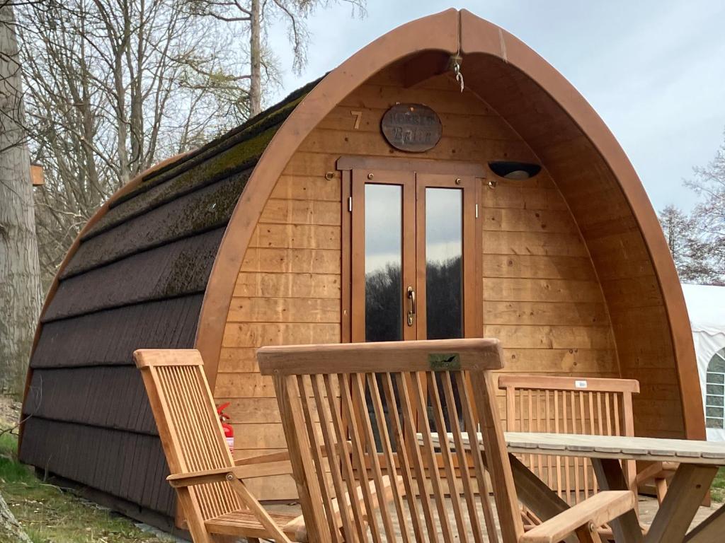 a dome house with two chairs and a table at Nr 6 Camping Pod mit Terrasse und Seeblick in Langenbernsdorf