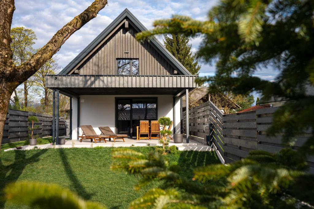 a house with a gambrel roof with a patio at The Alpine House Otto in Begunje na Gorenjskem