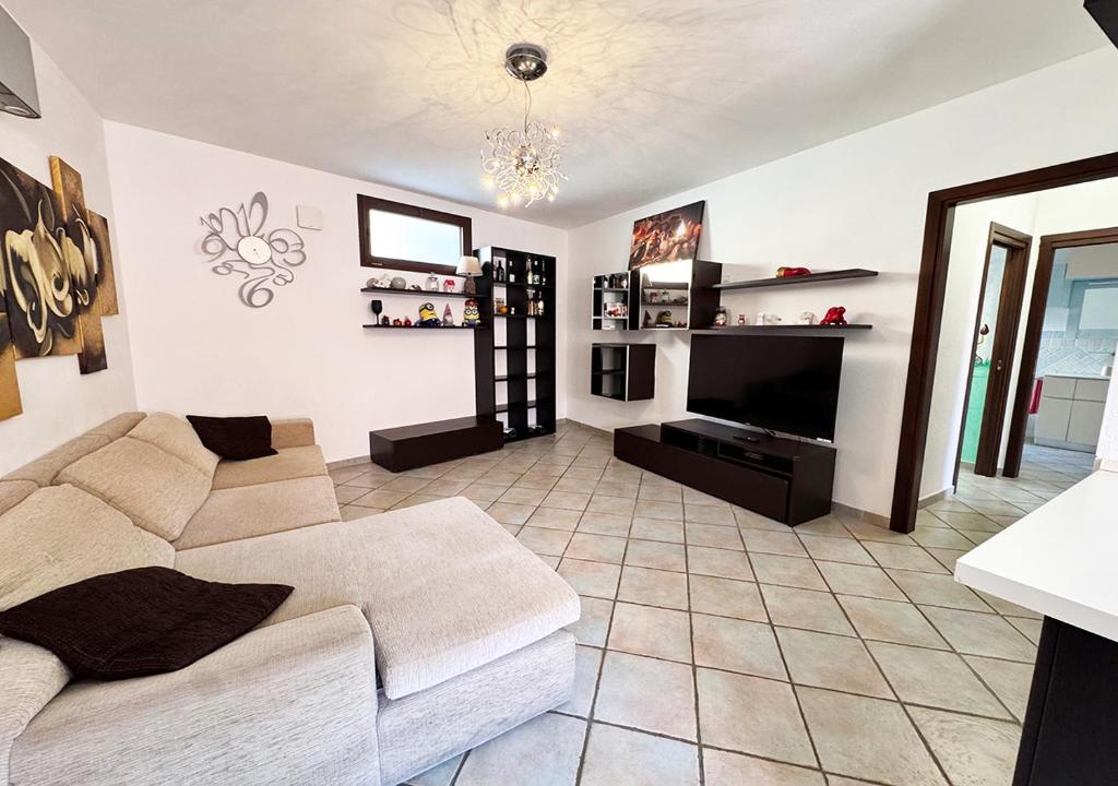 a living room with a couch and a television at Oasi della pace in La Maddalena