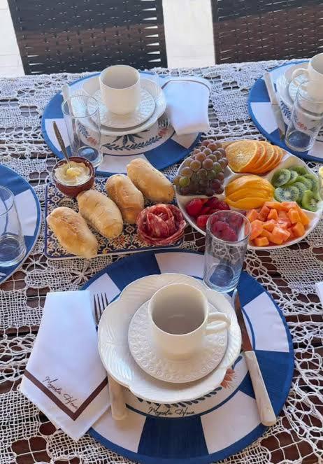 a table with plates of food and a cup of coffee at Joy Hostel in Salvador