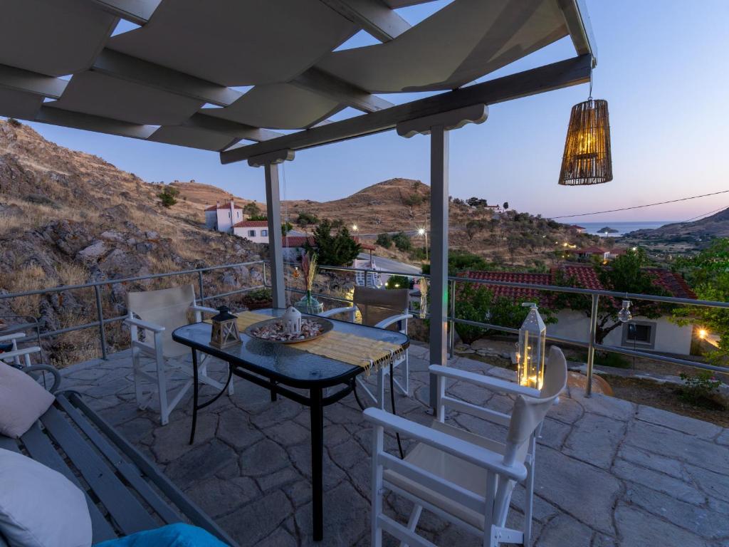 a patio with a table and chairs and a view at To Balkoni Thanos in Thános