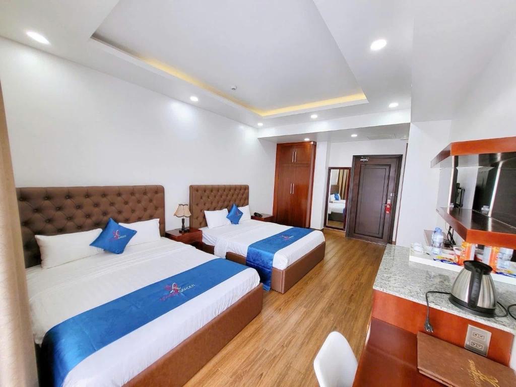 a hotel room with two beds and a television at Spring Garden Hotel in Long Khanh