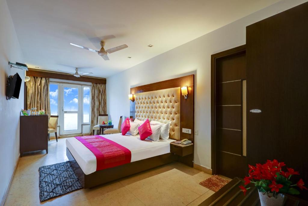 a bedroom with a large bed with pink pillows at Hotel The Metropolis Tourist Near Connaught Place And Ramakrishna Ashram Marg Metro Station in New Delhi