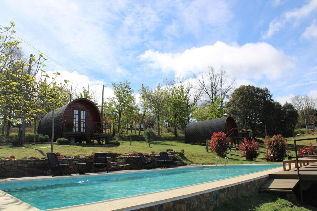 a resort with a swimming pool and a house at Quinta Da Devesa B1 in Vinhais