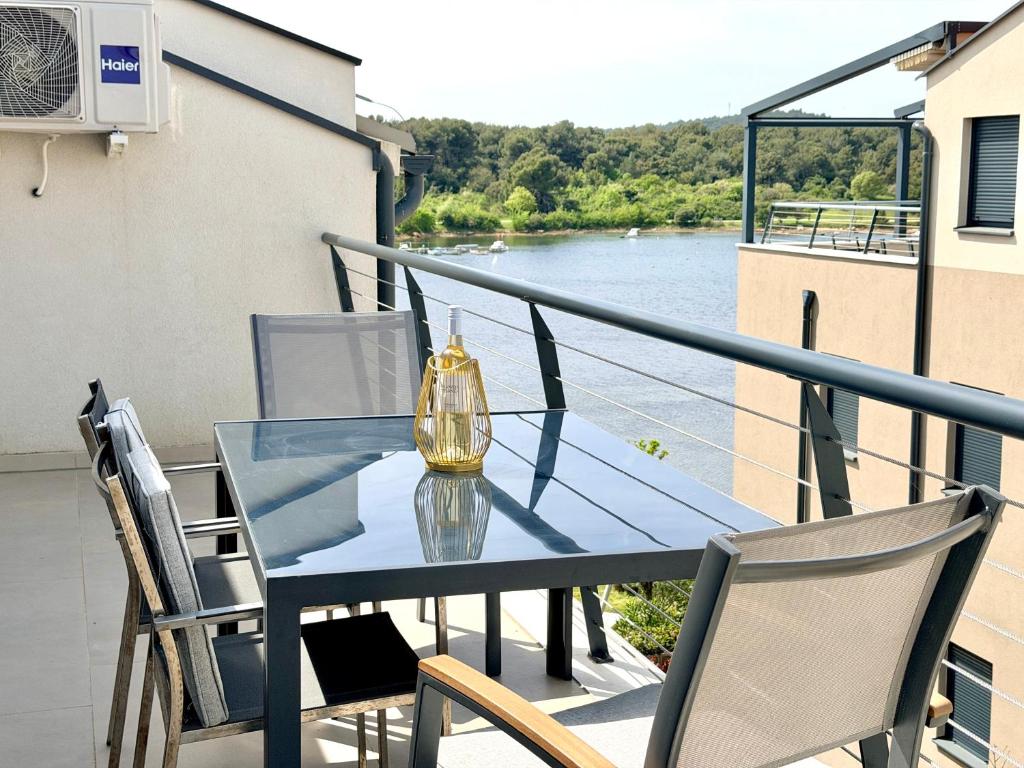 a glass table on a balcony with a view of a river at Apartment Lasta Medulin in Medulin