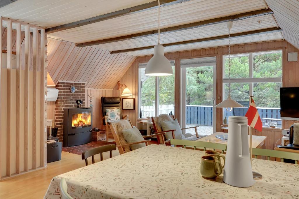 a living room with a table and a fireplace at Søndervang 4 in Nørre Nebel
