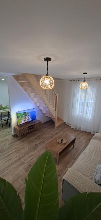a living room with a couch and a tv at L'Escale Chaunoise in Chauny