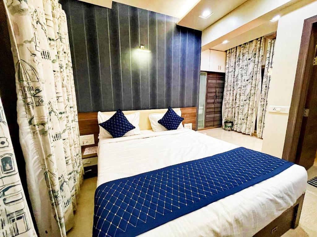 a bedroom with a bed with blue and white sheets at Tejas inn in Pune