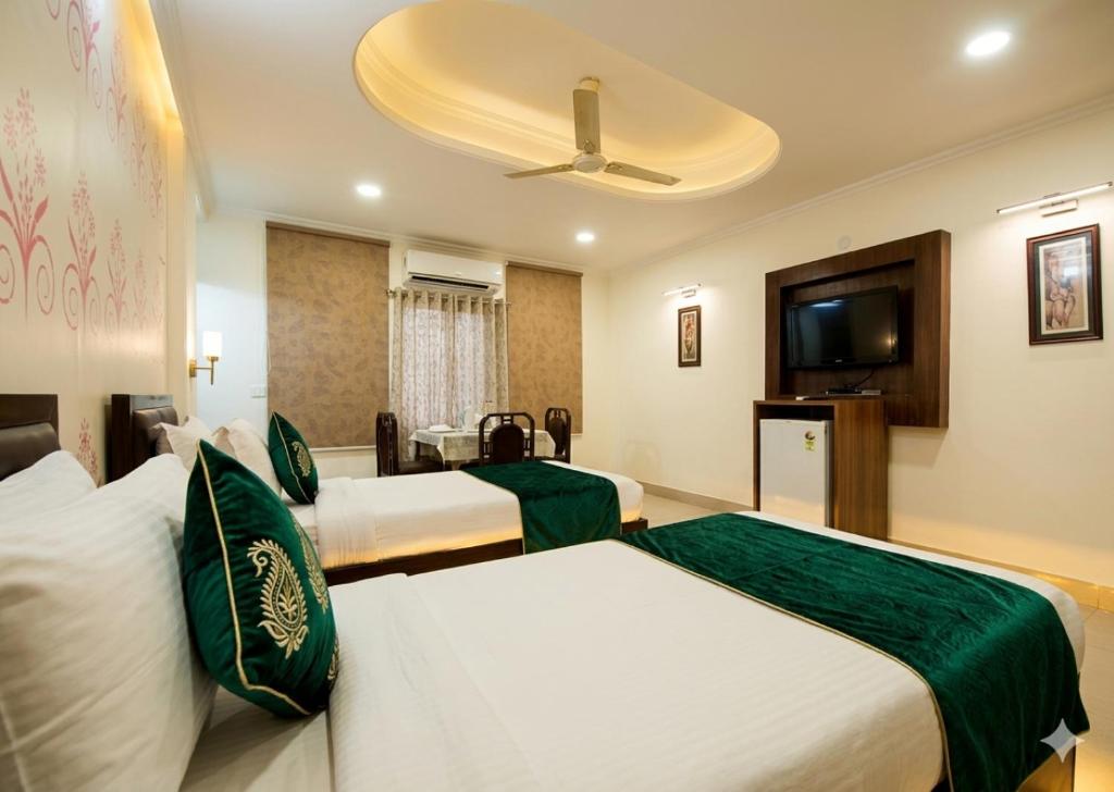 a hotel room with two beds and a flat screen tv at HOTEL DAKHA INTERNATIONAL - Karol Bagh, New Delhi in New Delhi