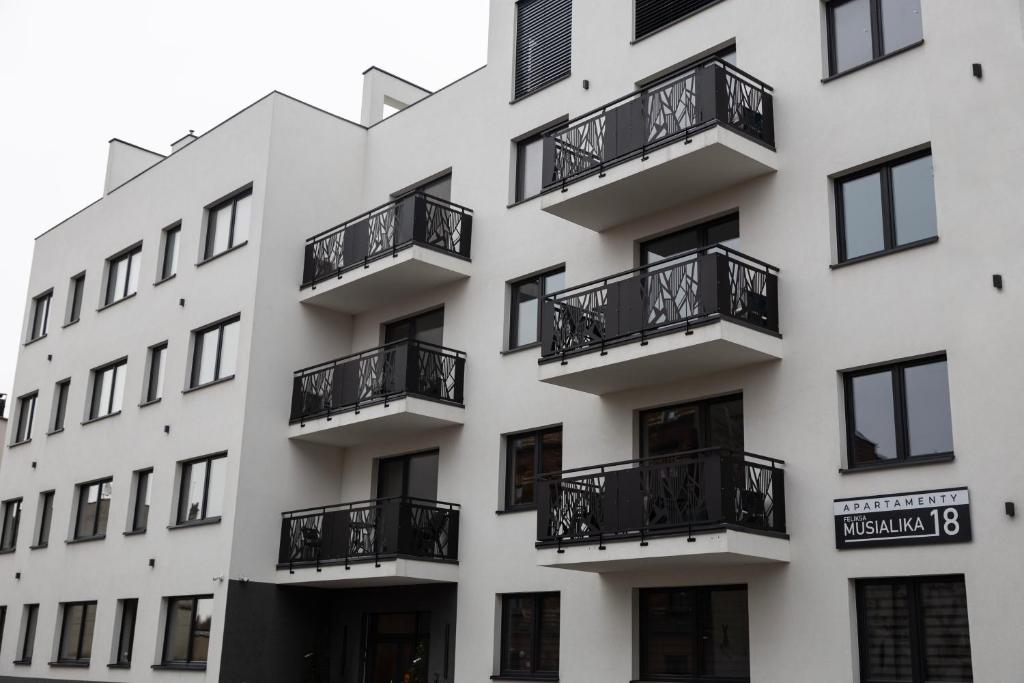 a white building with black balconies on it at Luxury Apartments Musialika 18 in Bytom
